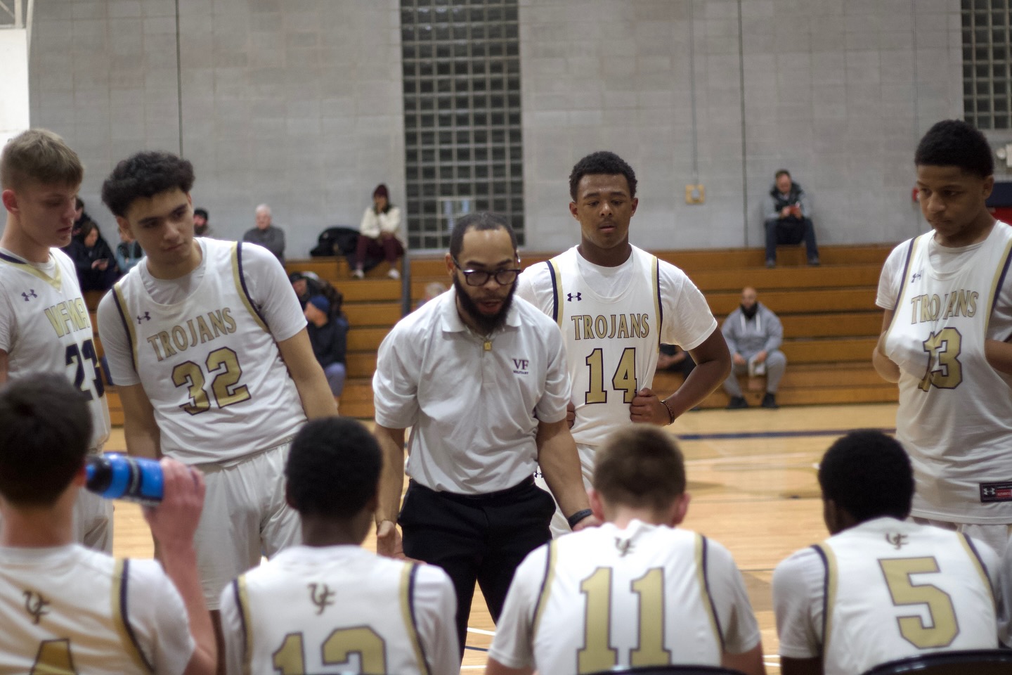 Coach Justin Lewis guiding his players during a basketball game